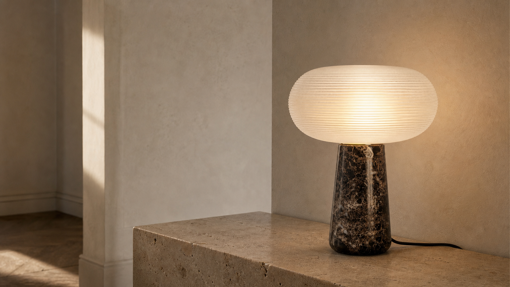 Maison Moya Brioche lamp lit on a travertine console